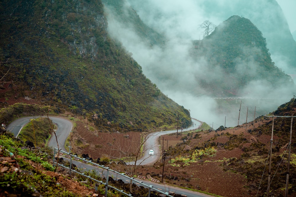 a winding road in the mountains surrounded by fog