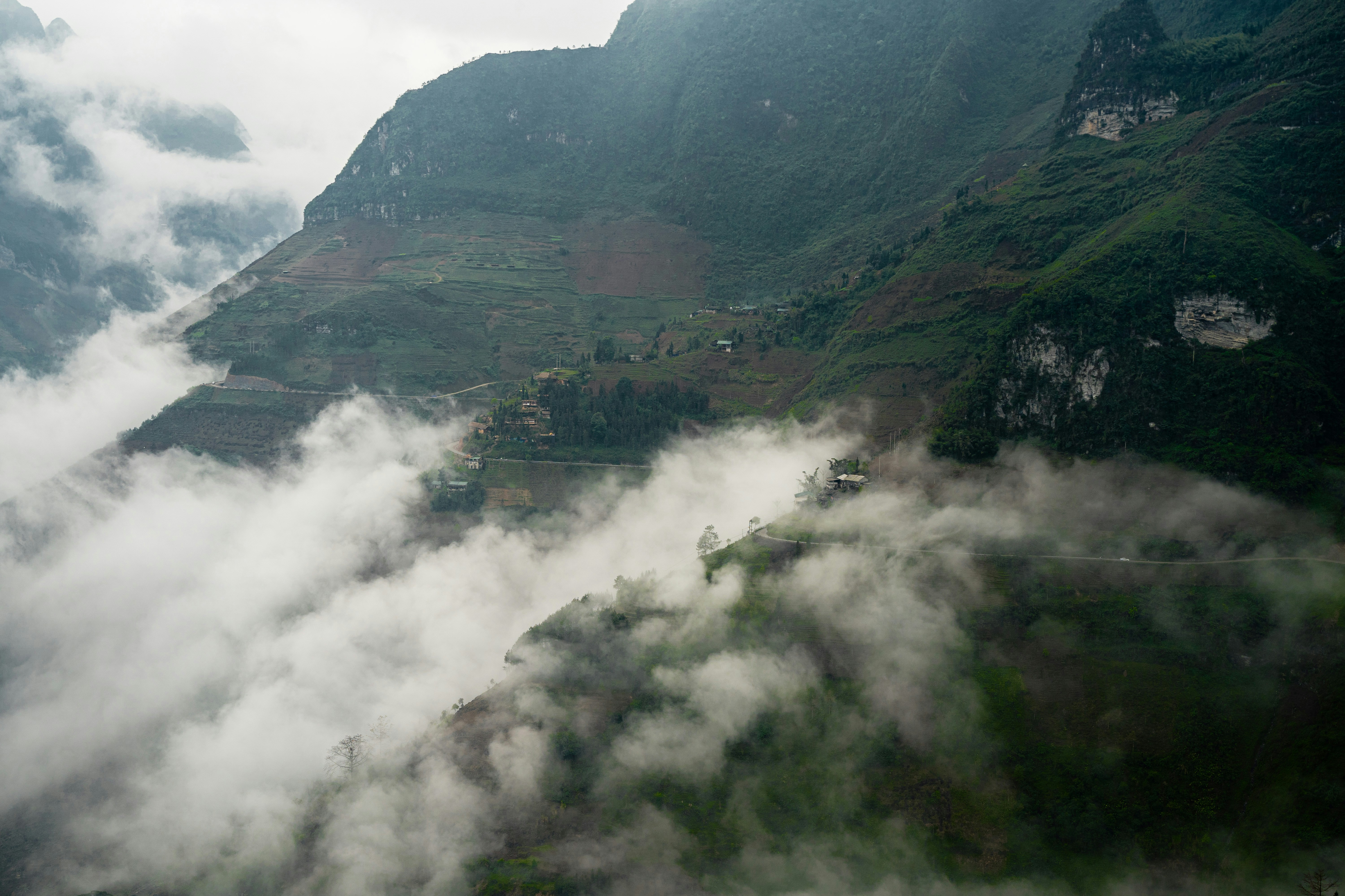a view of a valley with a mountain in the background, ha giang