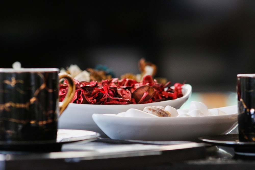 a table topped with two cups and a plate of food