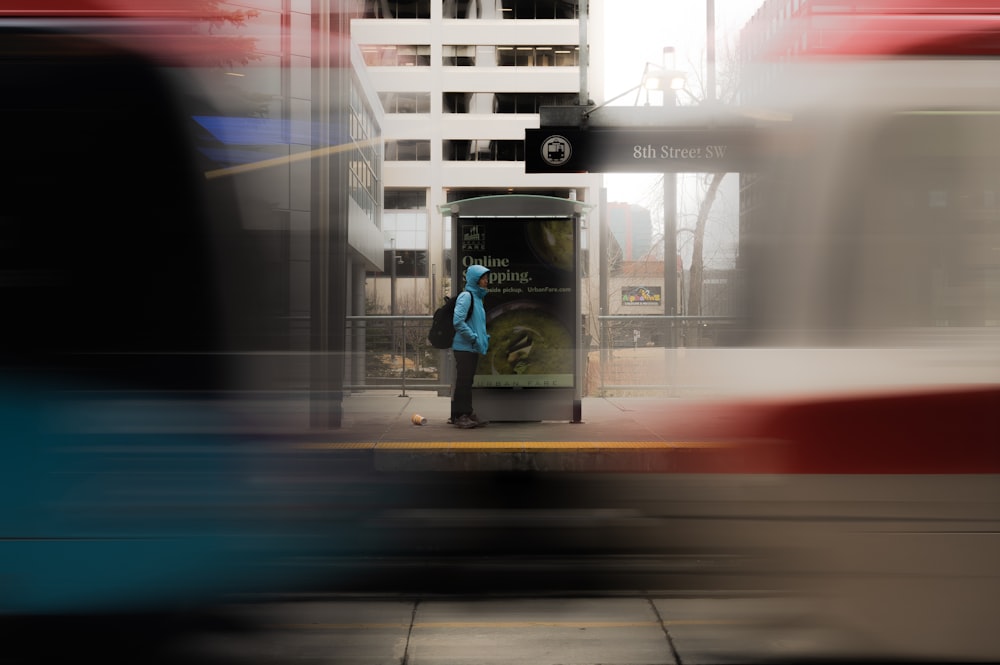 a blurry photo of a woman waiting at a bus stop