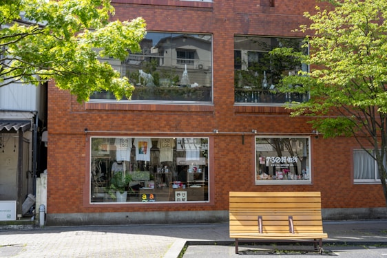A friendly store front of a local building materials shop with stacks of bricks and timber outside.