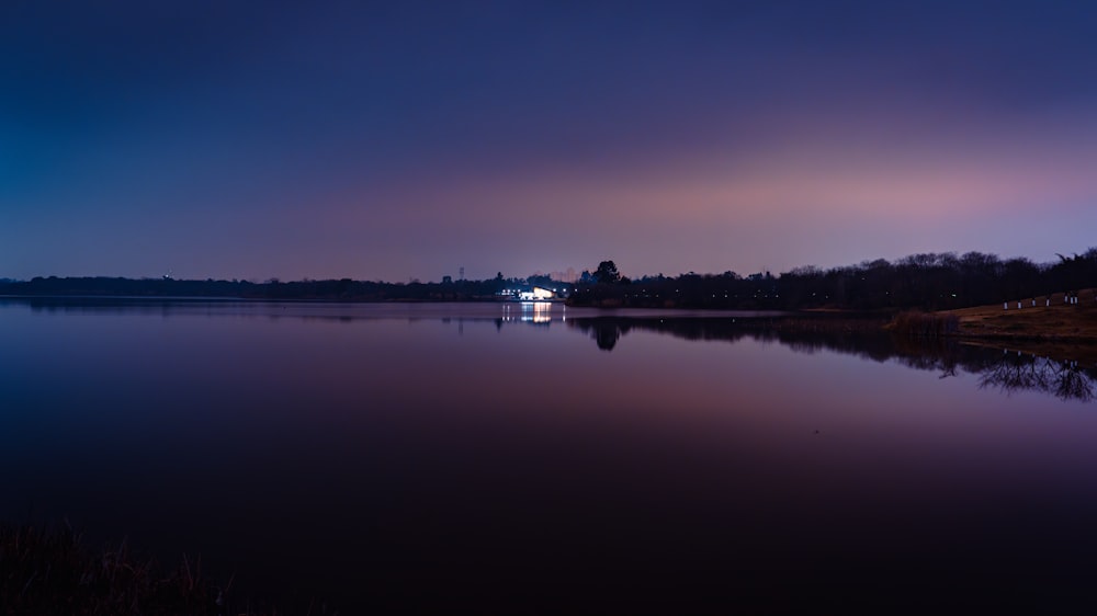 a large body of water with a house in the distance