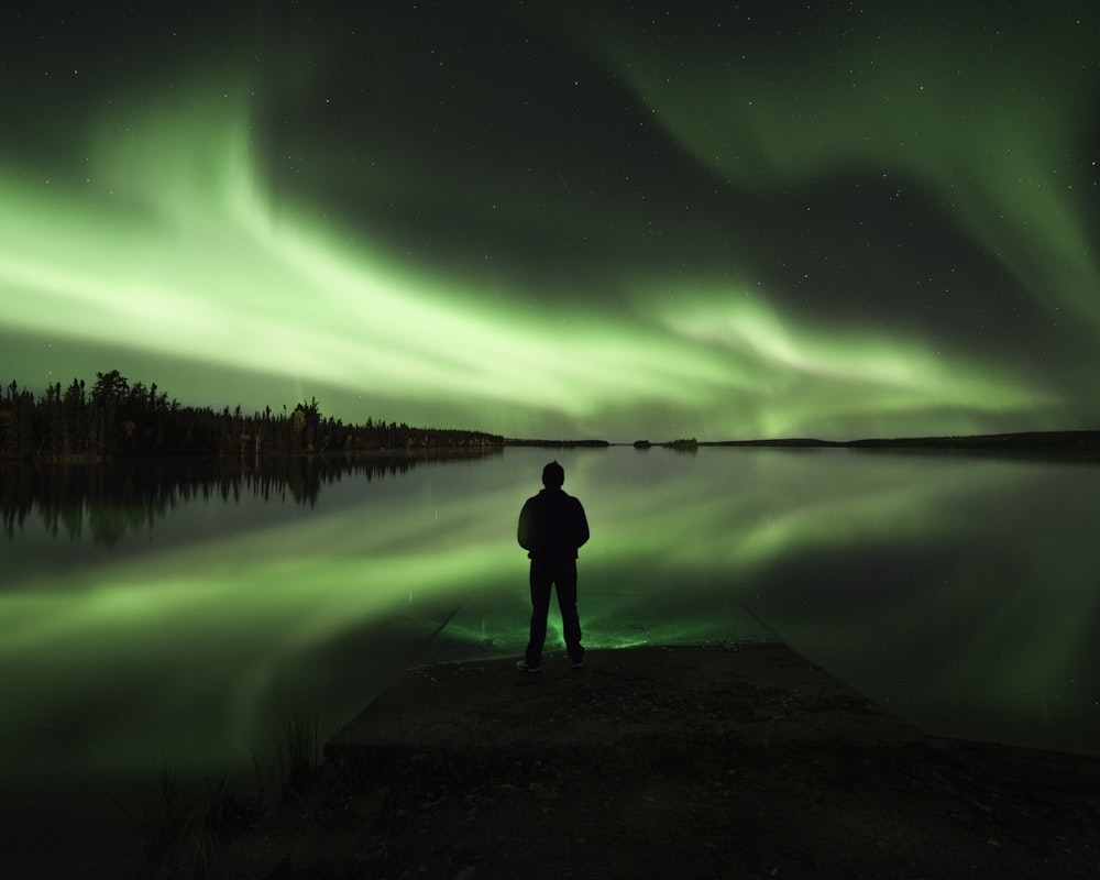 a man standing on a dock looking at the sky