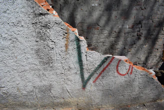 Graffiti removal in progress on a commercial brick wall, restoring the original surface.