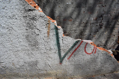 Graffiti removal in progress on a commercial brick wall, restoring the original surface.