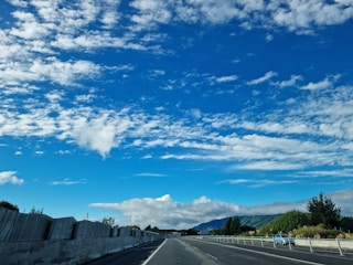 A tow truck on a highway with a clear blue sky in the background.
