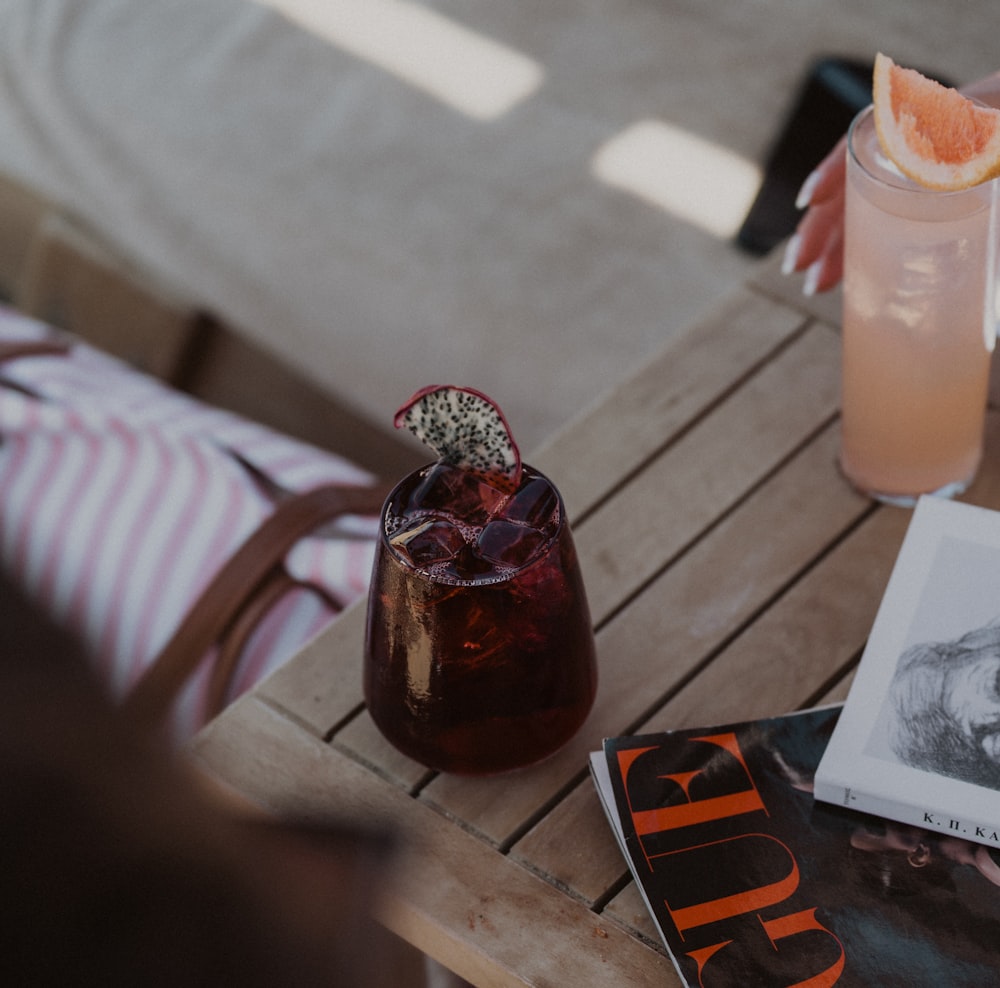 a person sitting at a table with a book and a drink