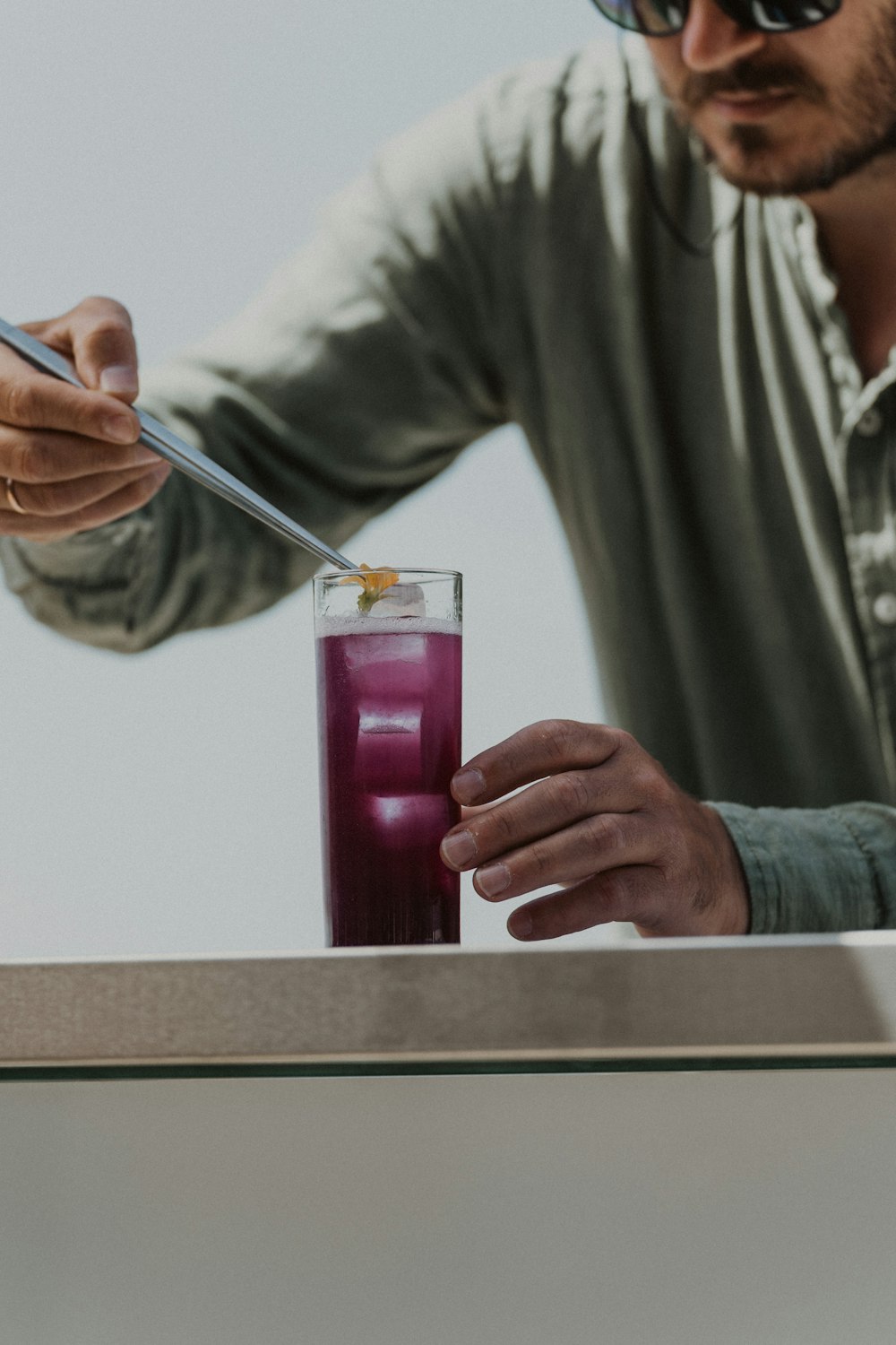 a man holding a knife and a glass with a liquid in it