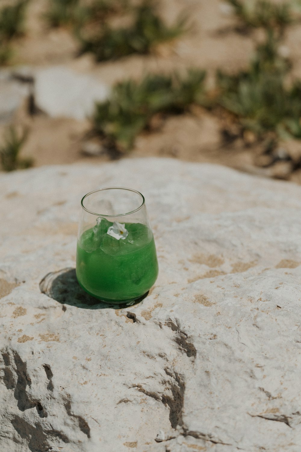 a green drink sitting on top of a rock