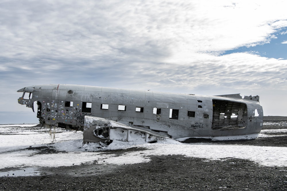 an old airplane sitting on top of a field covered in snow