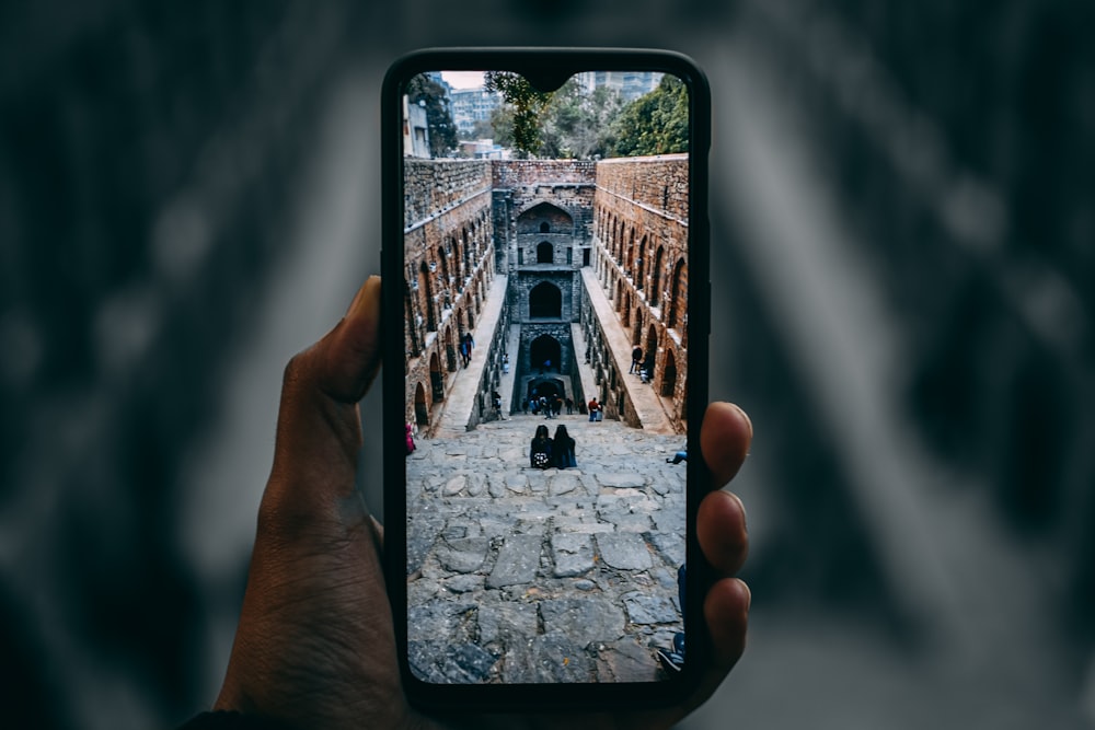 a person taking a picture of a building with a cell phone