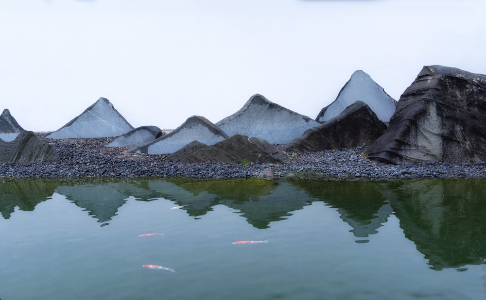 a group of mountains sitting next to a body of water