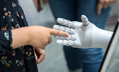 Close-up of a hand reaching toward a white robotic hand