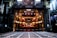 An elaborate theater interior viewed from the stage with ornate balconies and red seats. The theater is dimly lit with a few bright lights illuminating the balconies. The stage area appears to be under maintenance with visible metal framework.
