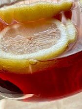 A close-up of a refreshing glass of lemonade with ice and lemon slices.