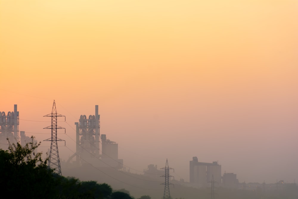 a hazy sky with power lines and buildings in the distance