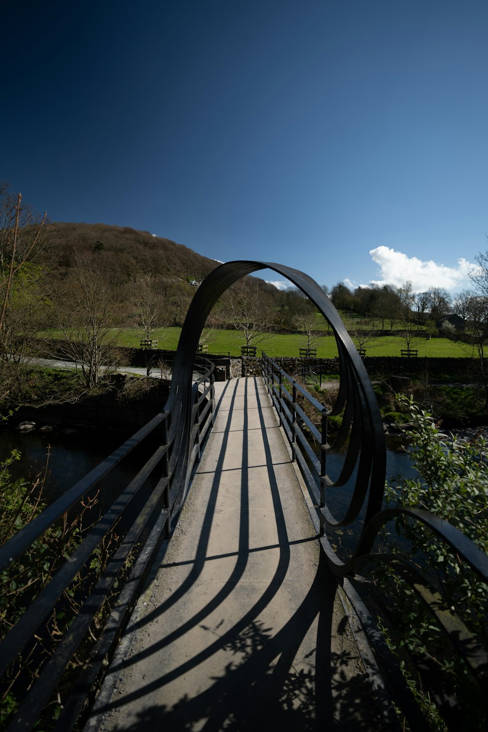 a wooden bridge over a river with a sky background