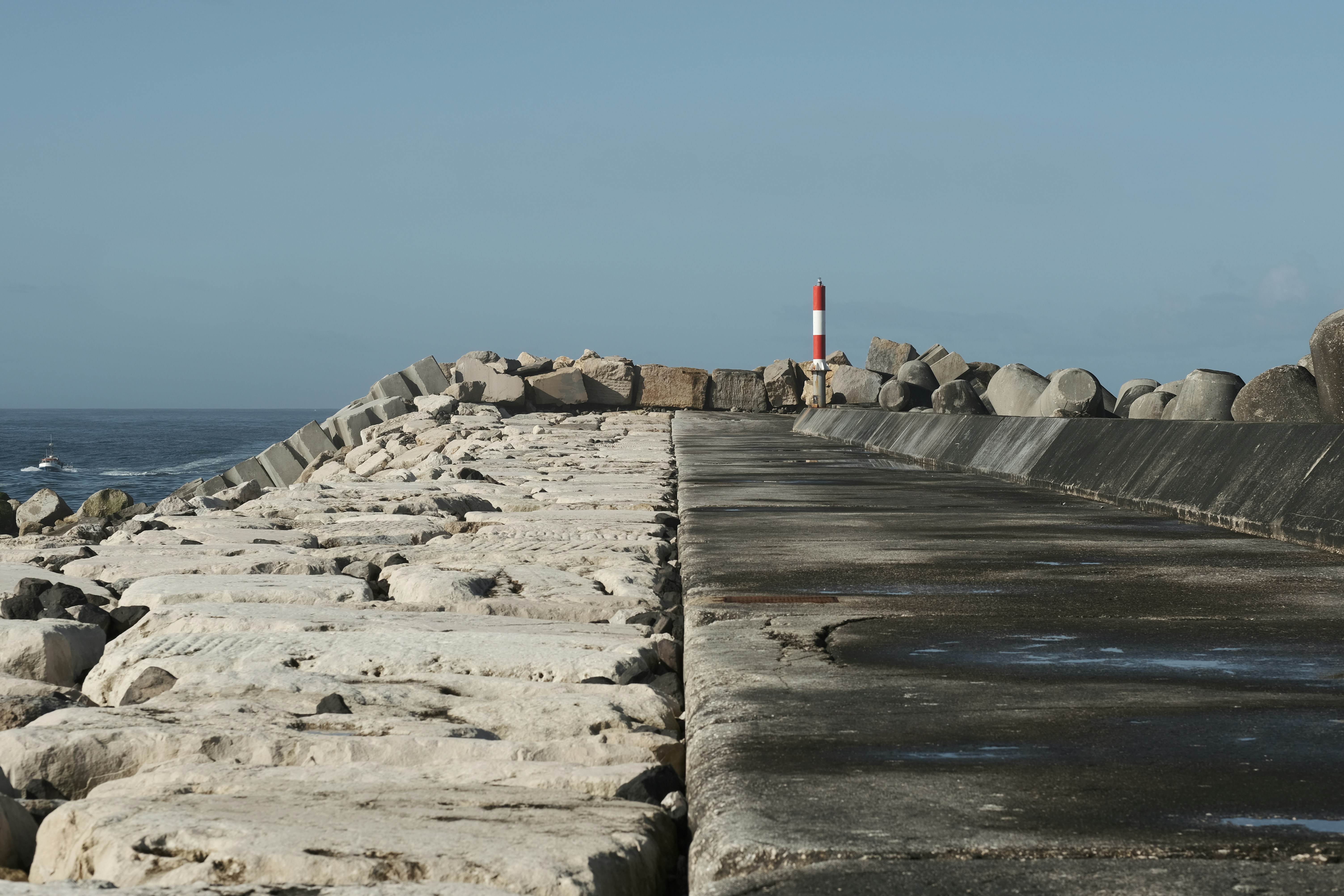 un lungo muro di pietra accanto a uno specchio d'acqua
