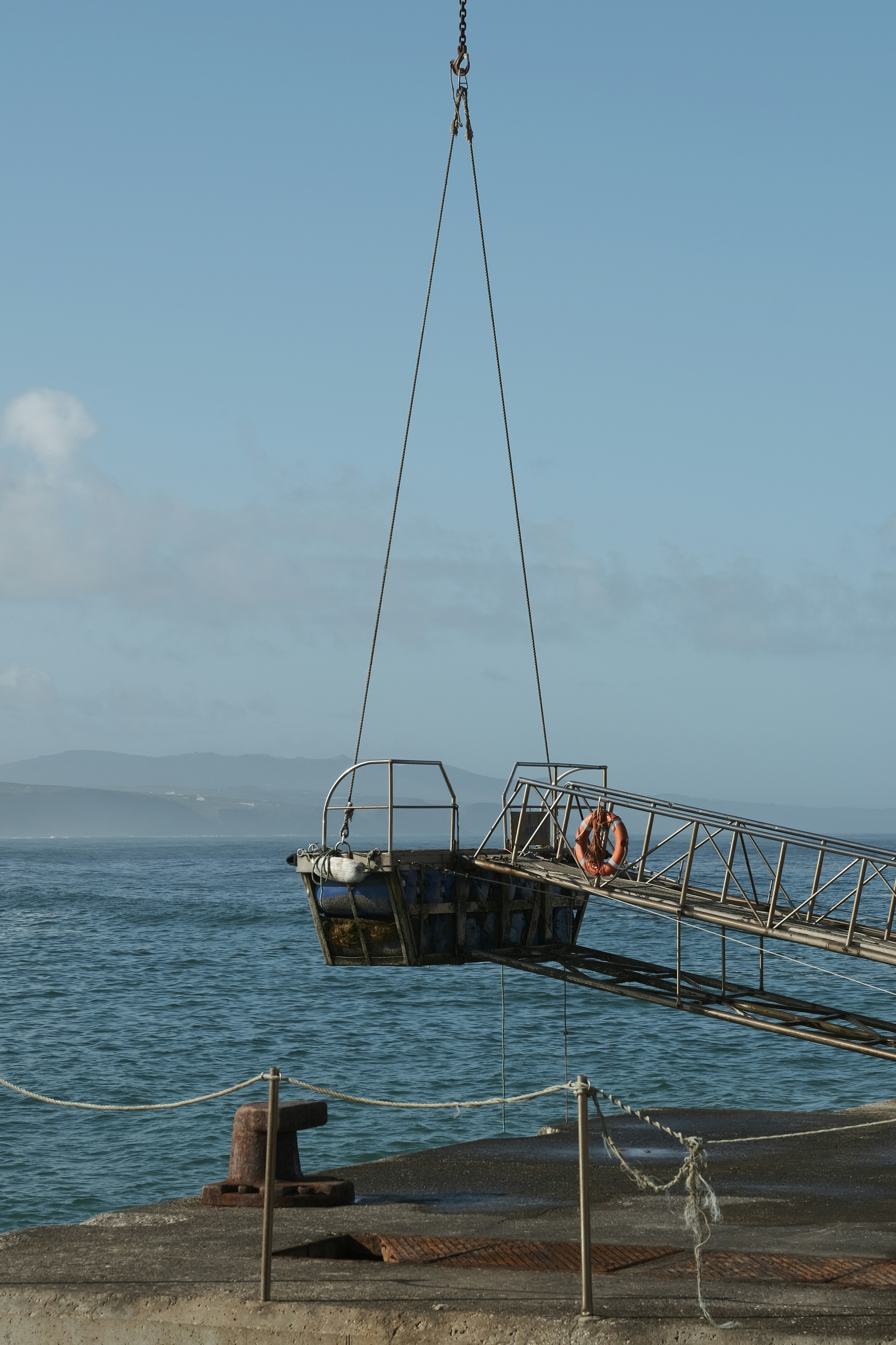 Una gru sta sollevando una barca in acqua