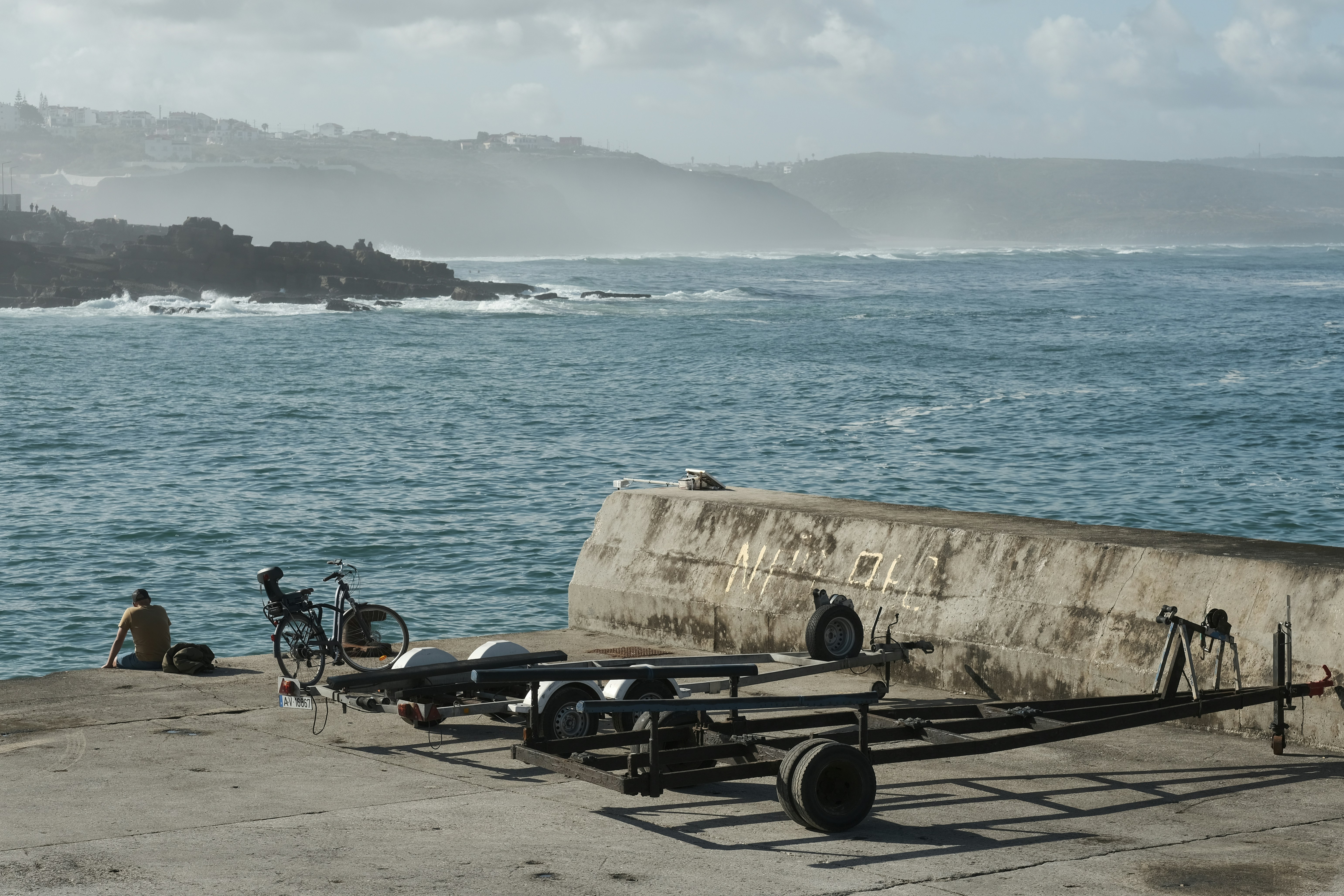 Una barca seduta sulla cima di un molo di cemento vicino all'oceano