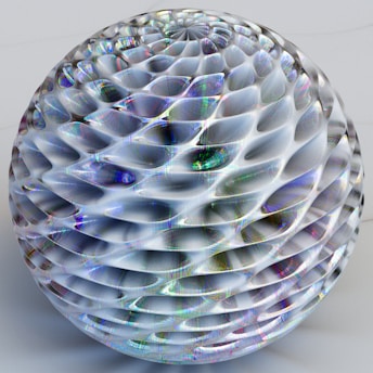 Detailed geometric sphere with a honeycomb texture that reflects light, creating a spectrum of colors on its surface.