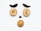 Various nuts and dried fruits arranged on a white surface to resemble a face, with two long dark fruits as eyebrows, two round nuts as eyes, a small dark nut as the nose, and a larger nut as the mouth.