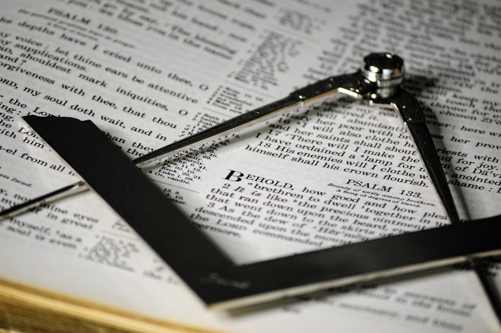 a close up of an open book with a clock on top of it