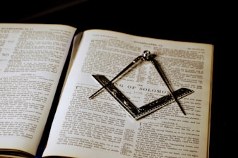 an open book with a masonic symbol on it