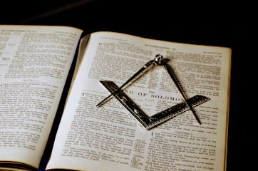 an open book with a masonic symbol on it