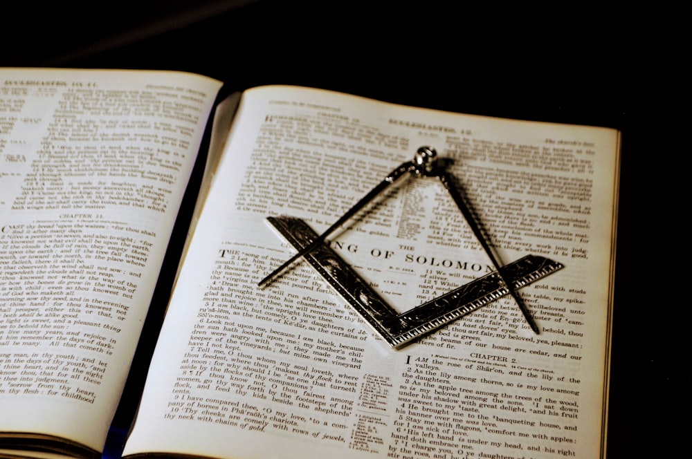 an open book with a masonic symbol on it