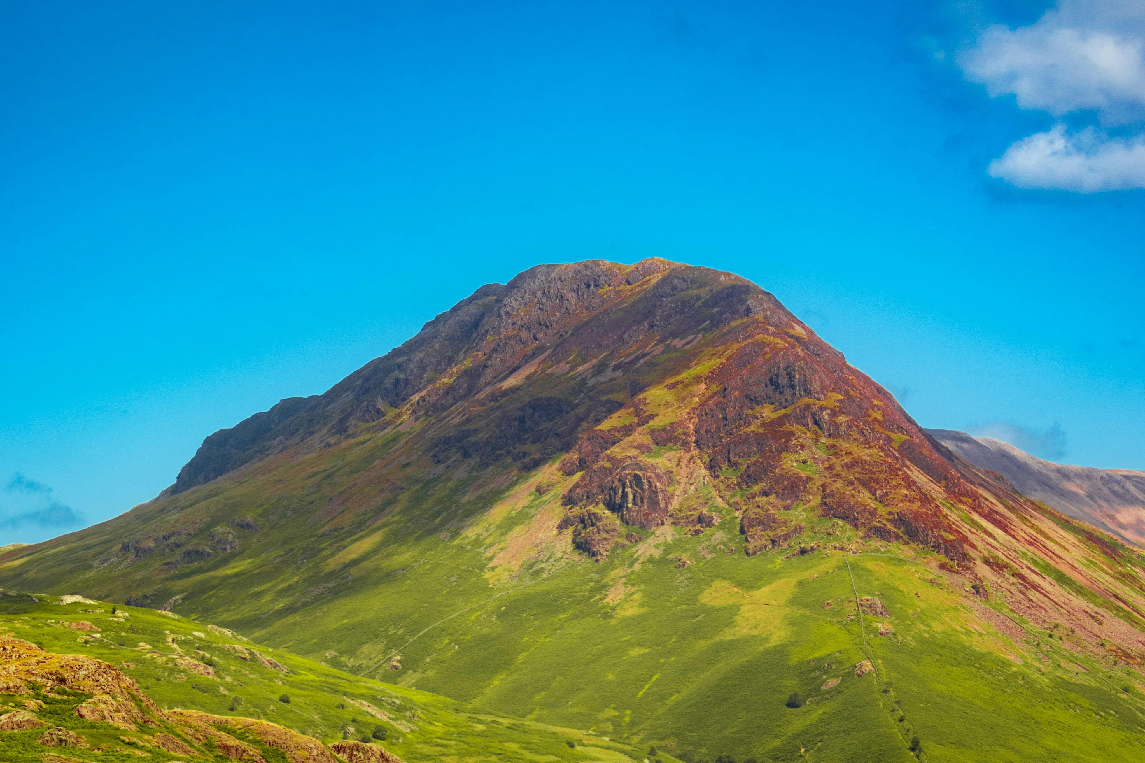 Ein grüner Berg mit blauem Himmel im Hintergrund