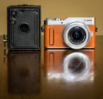 A close-up of a vintage film camera next to a modern VR headset on a dark minimalist desk.