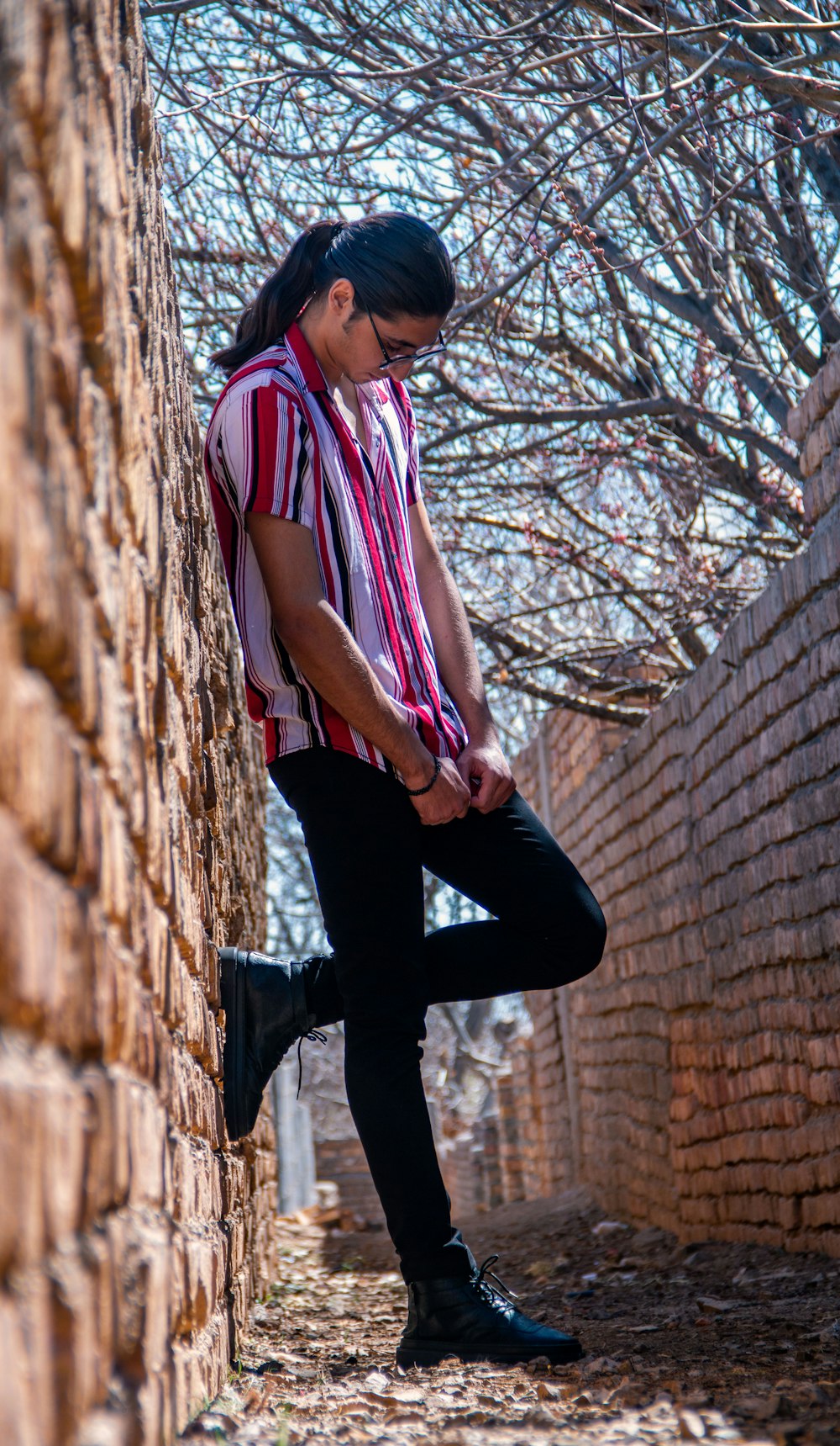 a person leaning against a brick wall