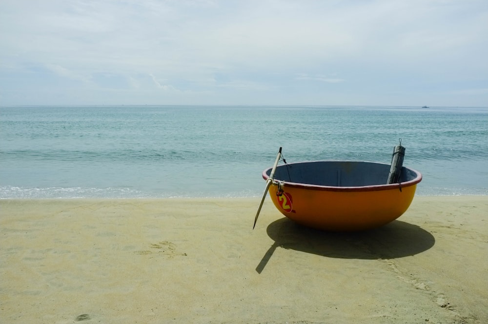 a yellow boat sitting on top of a sandy beach