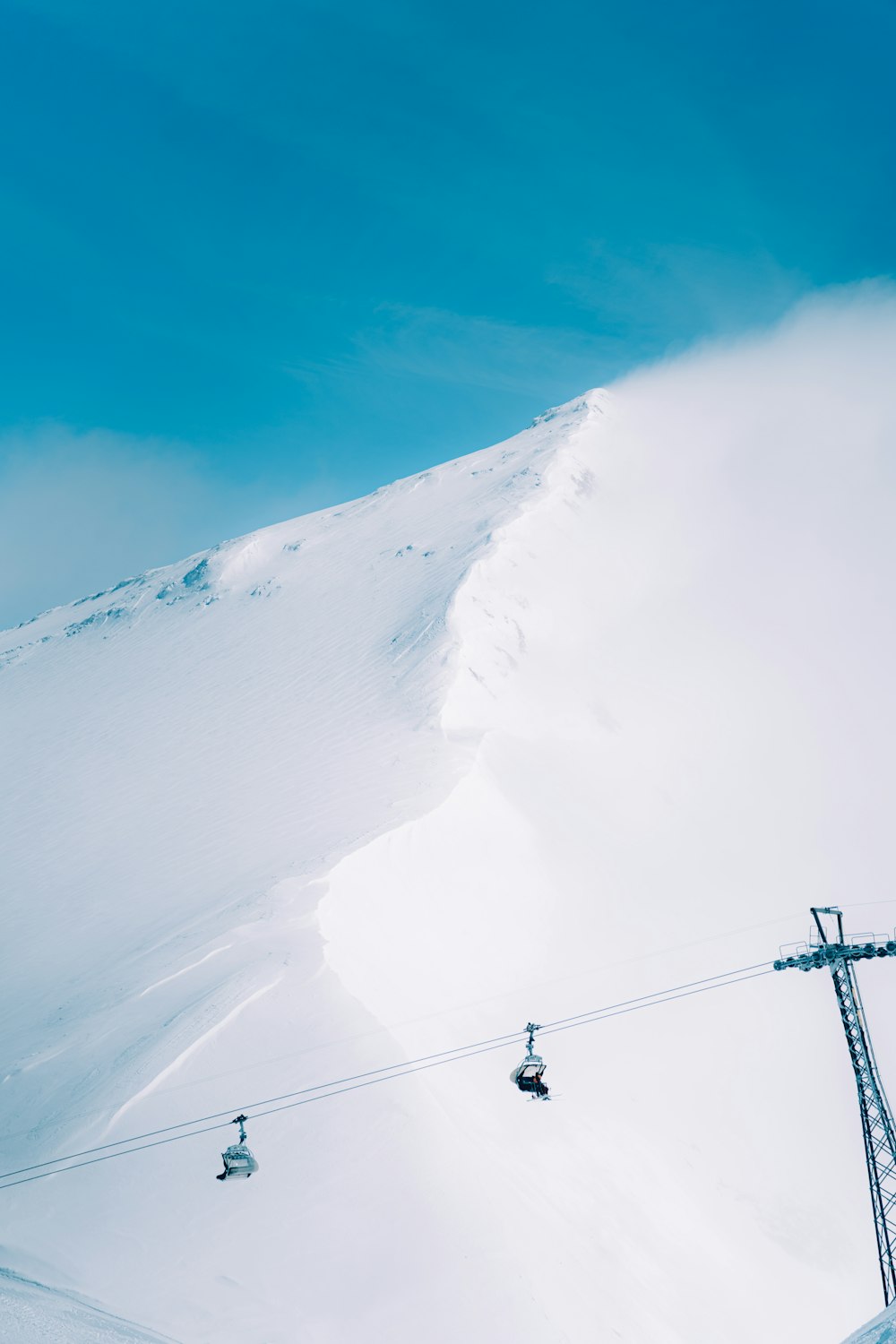 ein Skilift, der einen schneebedeckten Berg hinauffährt
