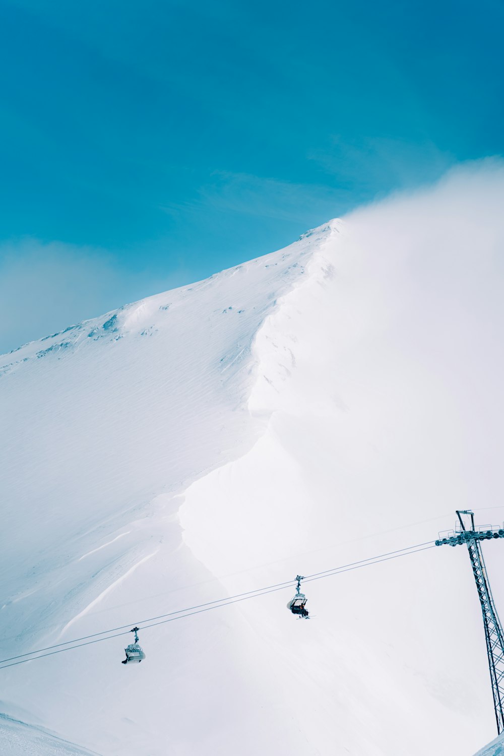 a ski lift going up a snowy mountain