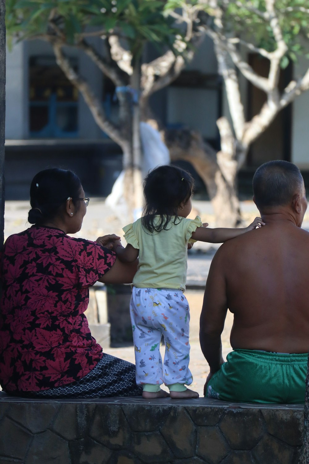 a man and two children sitting on a bench