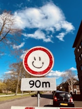 A cheerful driving instructor smiling while explaining road signs to a student in a car.