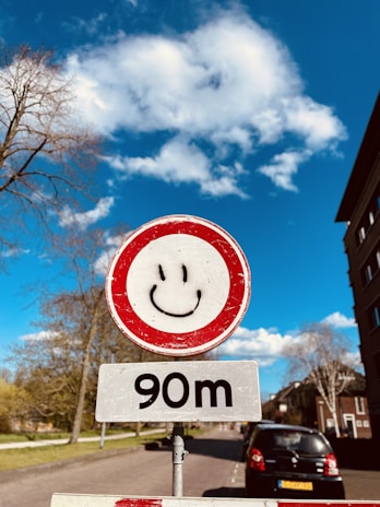 A cheerful driving instructor smiling while explaining road signs to a student in a car.