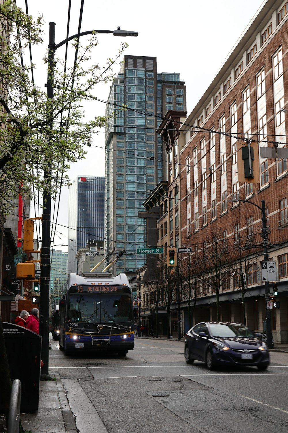 a bus driving down a street next to tall buildings