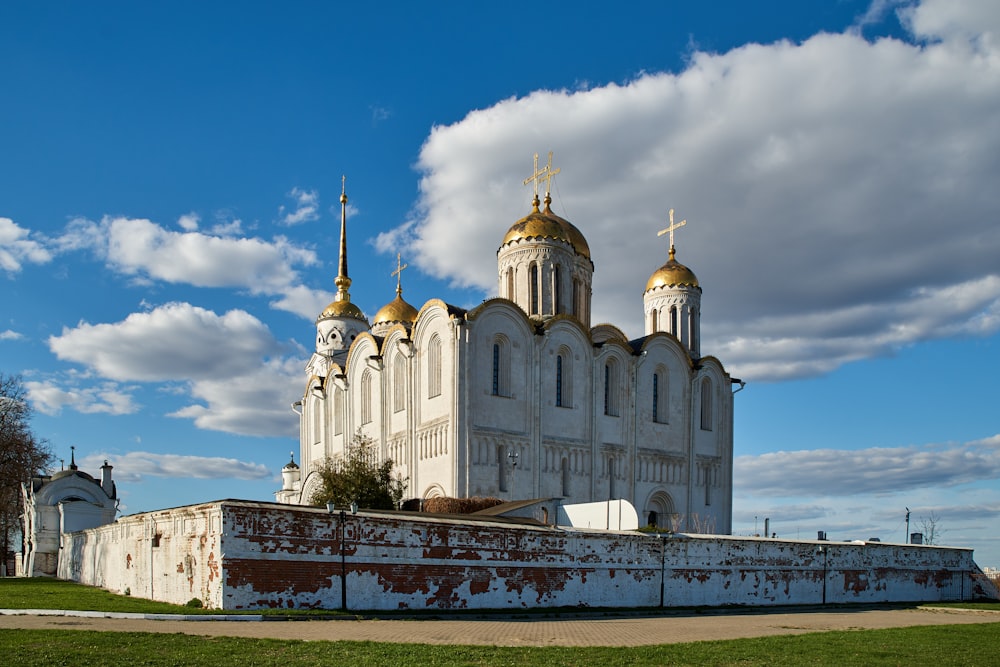 a large white building with gold domes on top of it