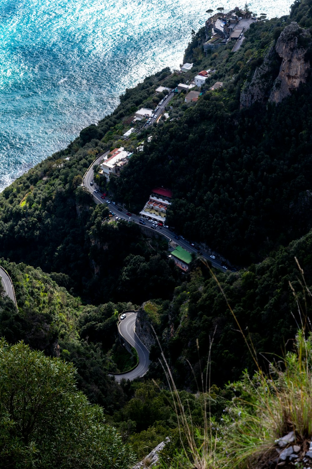 a winding road on the side of a mountain next to the ocean