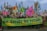 A large group of people are gathered in a city street, participating in a protest or demonstration. They are holding a green banner with the words 'NO NATURE NO FUTURE' written on it. Various colorful flags with images of animals and slogans are being waved by the attendees. The backdrop includes historical architecture, suggesting a significant urban location.
