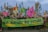 A large group of people are gathered in a city street, participating in a protest or demonstration. They are holding a green banner with the words 'NO NATURE NO FUTURE' written on it. Various colorful flags with images of animals and slogans are being waved by the attendees. The backdrop includes historical architecture, suggesting a significant urban location.