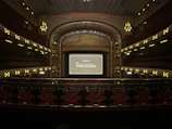 An elegant theater setting with screens illuminated by cinematic AI-generated visuals.