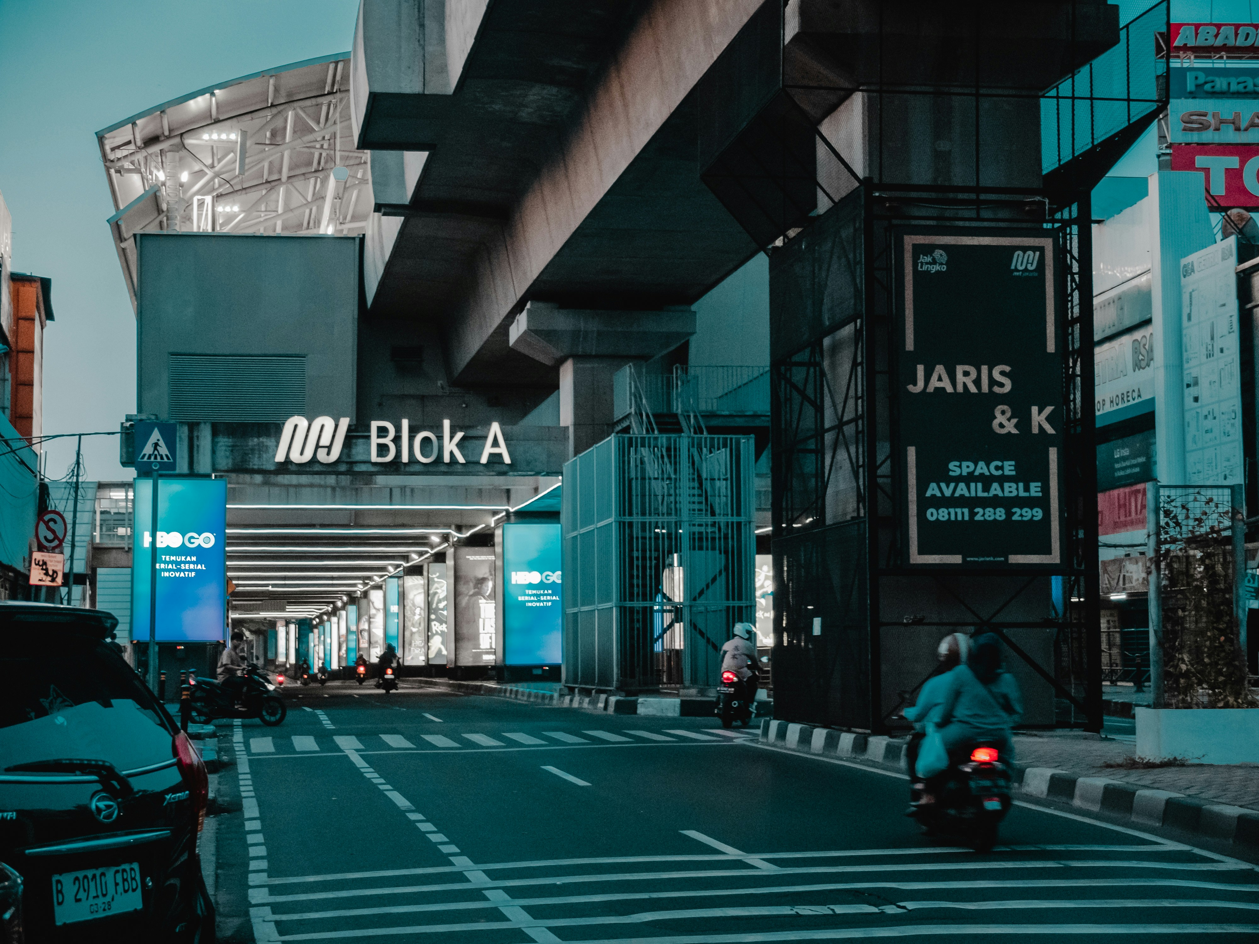 Honda urban motorcycle in city street at night, neon reflections, modern architecture