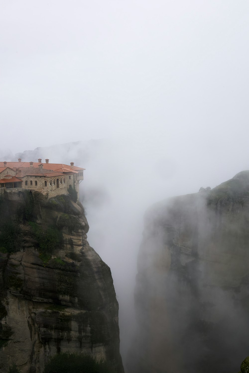 a castle on top of a cliff in the fog