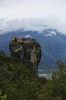 A misty morning view of the Tiger’s Nest monastery perched on a cliffside.