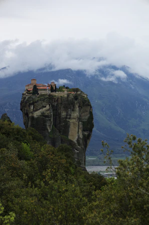 A misty morning view of the Tiger’s Nest monastery perched on a cliffside.