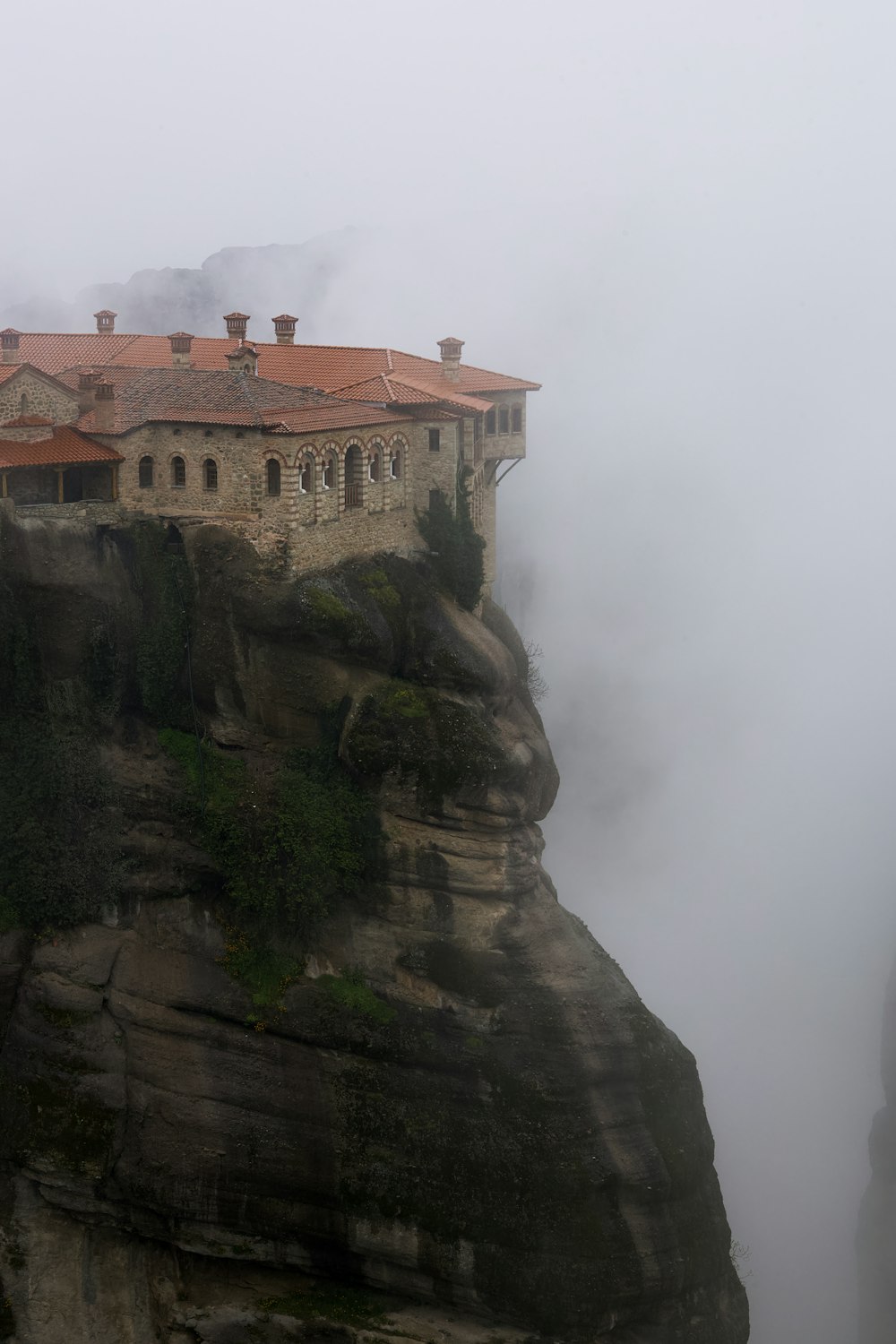 a castle on top of a cliff in the fog